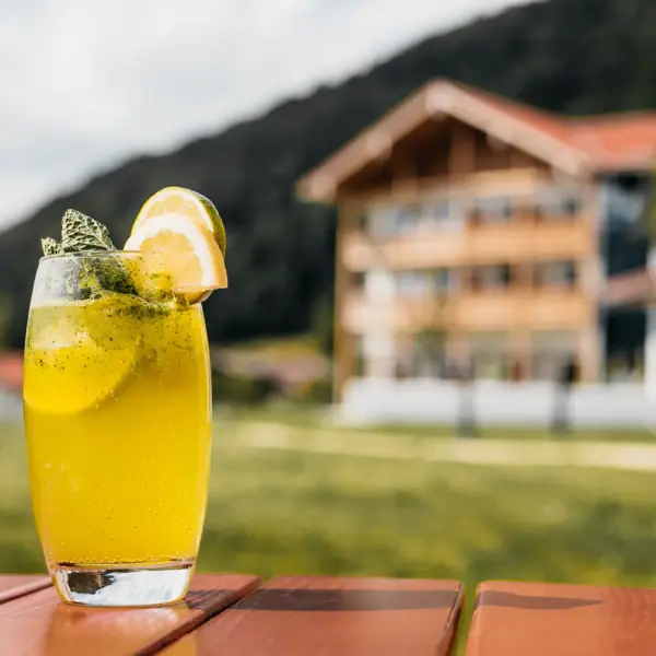 Drinken bij aja Ruhpolding Limonade in een glas en met de aja Ruhpolding op de achtergrond.