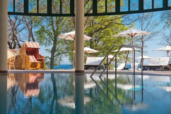 SPA Ein Pool mit einem Liegestuhl und Sonnenschirmen.