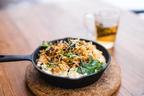 Kaas-spaetzle Een pan met eten op een tafel.