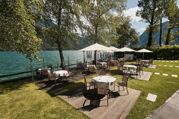 Een tafel en stoelen op een terras aan het meer.