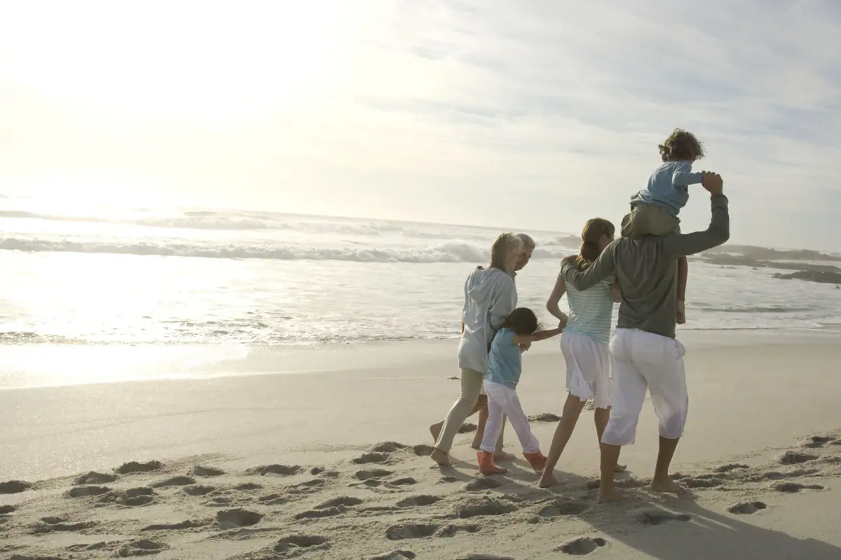 Een gezin wandelt langs het strand.