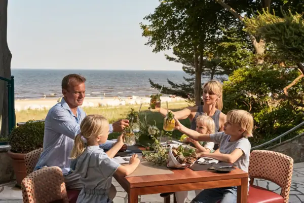 Een groep mensen zit aan een tafel met drankjes.