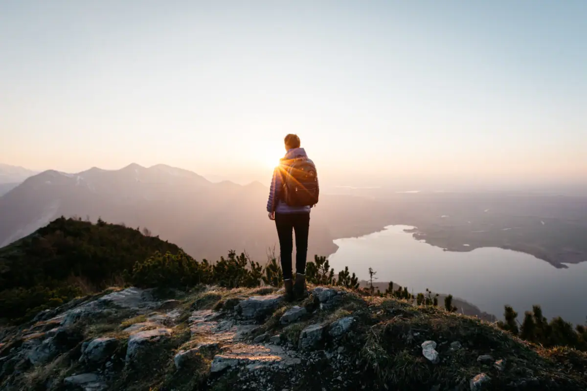 Wandelen Garmisch-Partenkirchen Iemand staat op een heuvel en kijkt in de zon.