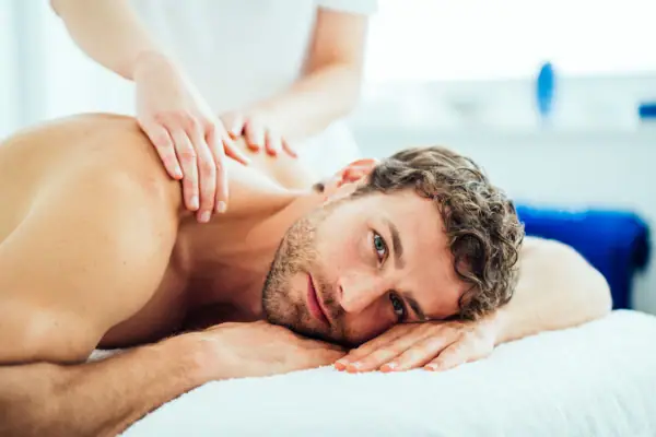 Een man ligt op een massagetafel.