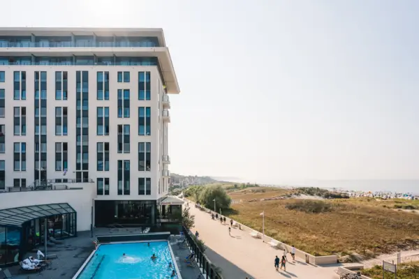 Een gebouw met een zwembad en mensen die voorbij lopen.