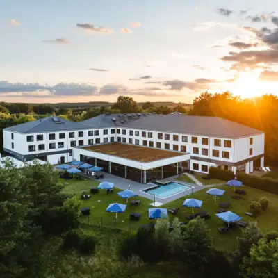 aja Bad Saarow Een gebouw met een zwembad en parasols in het centrum.
