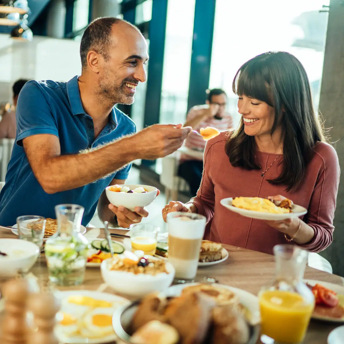 Een man en een vrouw eten aan een tafel.