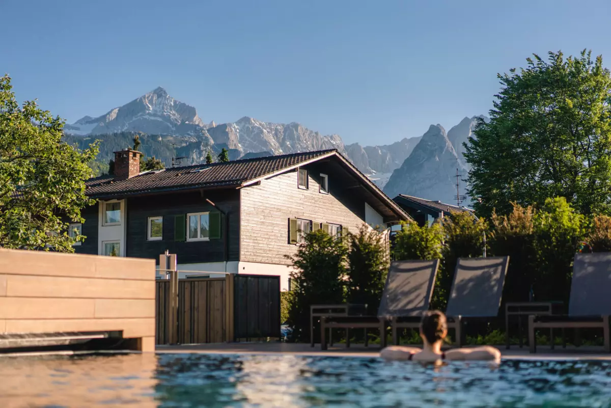 Buitenzwembad Een persoon in een zwembad voor een huis.