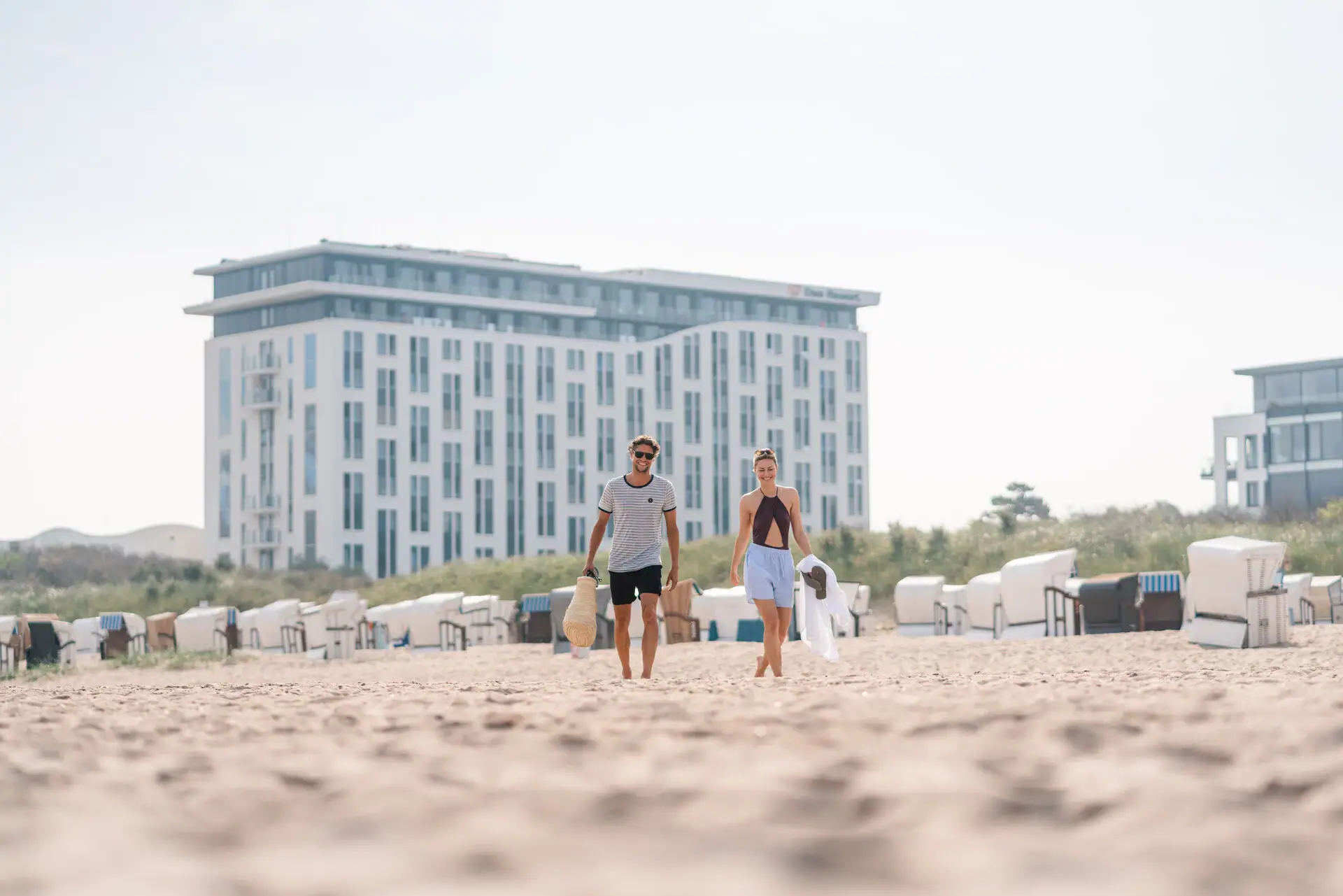 Een man en een vrouw lopen langs het strand.