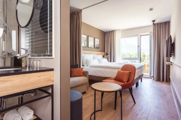 Zimmer Ein modernes, helles Hotelzimmer mit einem Bett und einem Tisch.