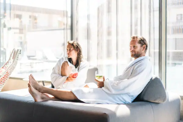 SPA Lounge Een man en een vrouw in badjassen zitten op een bank.