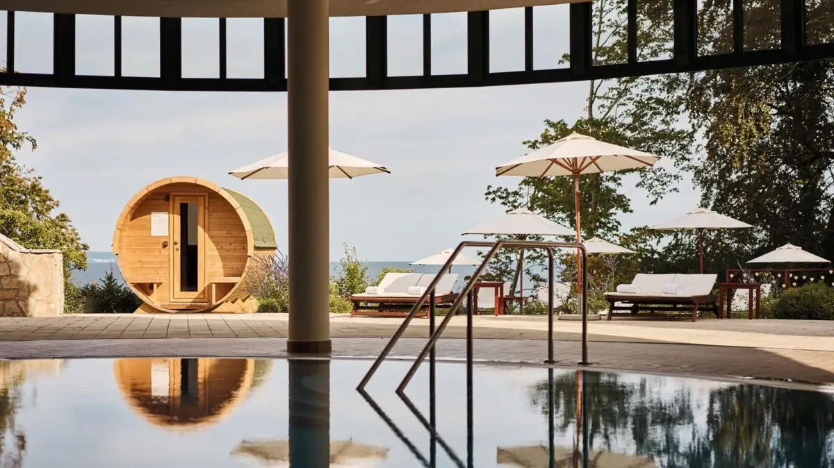 Een zwembad met parasols en een ton.