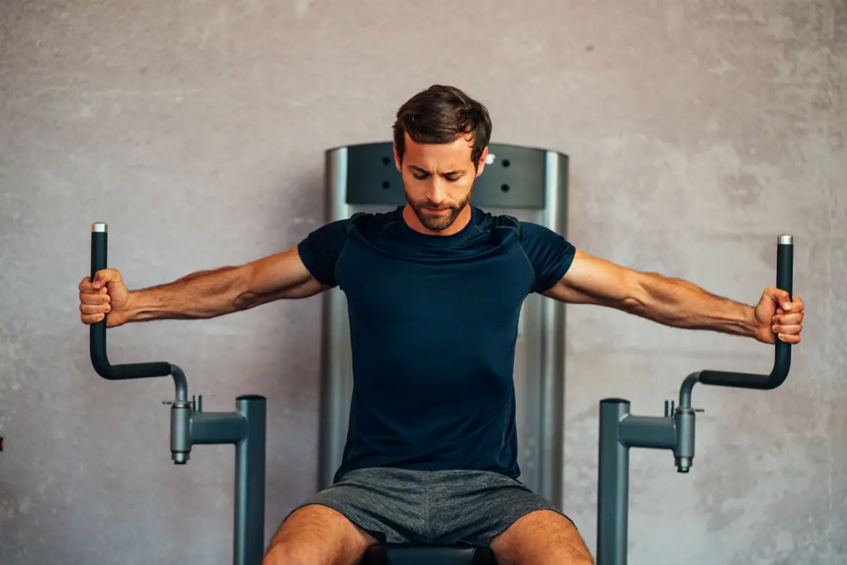 Een man traint op een fitnessapparaat.