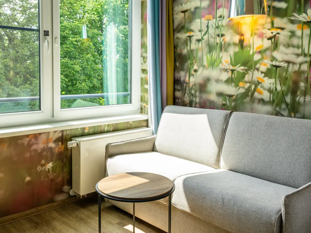 Bank en tafel in een kamer met behang.