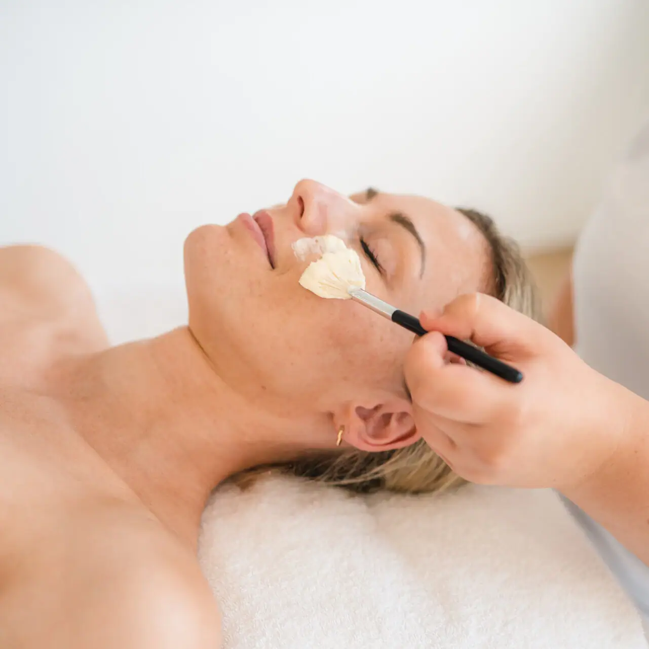 Toepassingen bij de aja Warnemünde Een vrouw ligt op de bank met een borstel op haar gezicht.