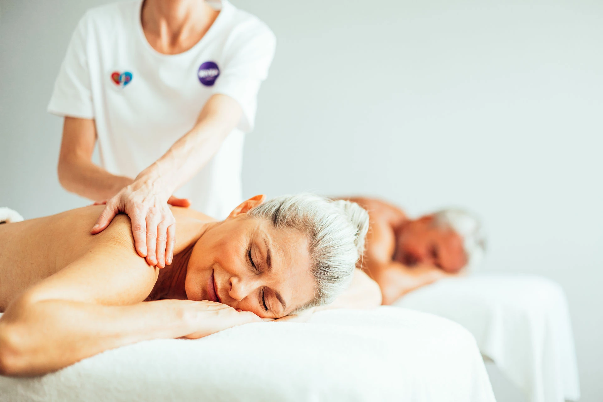 Een vrouw en een man liggen op een bed.