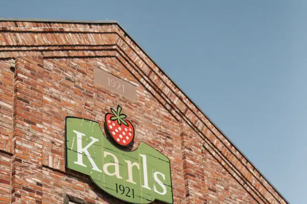 Karls Avonturendorp Elstal Een bord op de zijkant van een bakstenen gebouw.