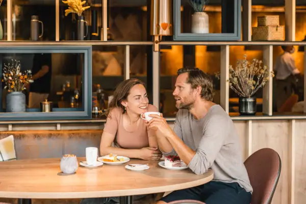 Kaffeepause Ein Mann und eine Frau sitzen an einem Tisch mit Essen.