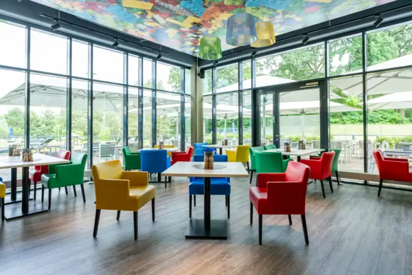Kleurrijke stoelen en tafels in één ruimte.