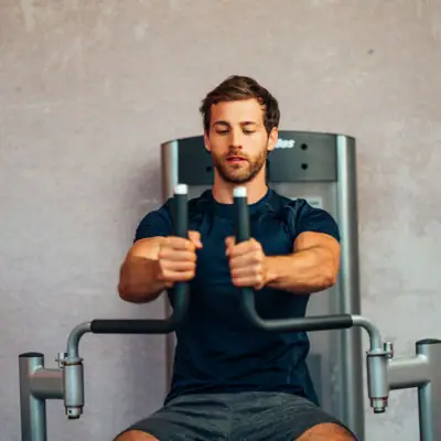 Een man traint op een fitnessapparaat.