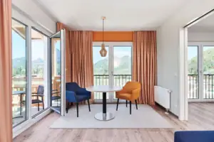 Suite met balkon aja Ruhpolding Een kamer met een tafel en stoelen.