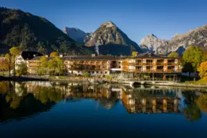 aja Fürstenhaus aan de Achensee Een gebouw naast een waterpartij met bomen op de achtergrond.