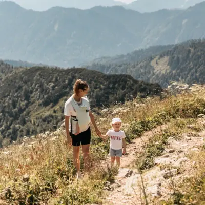Een vrouw en een kind die op een berg aan het wandelen zijn.