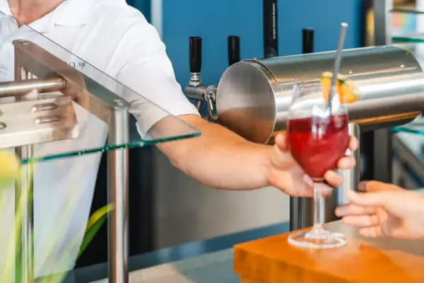 Een man geeft een klant een drankje.