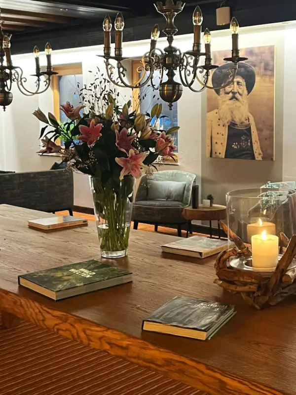 Een tafel met boeken en een vaas met bloemen.