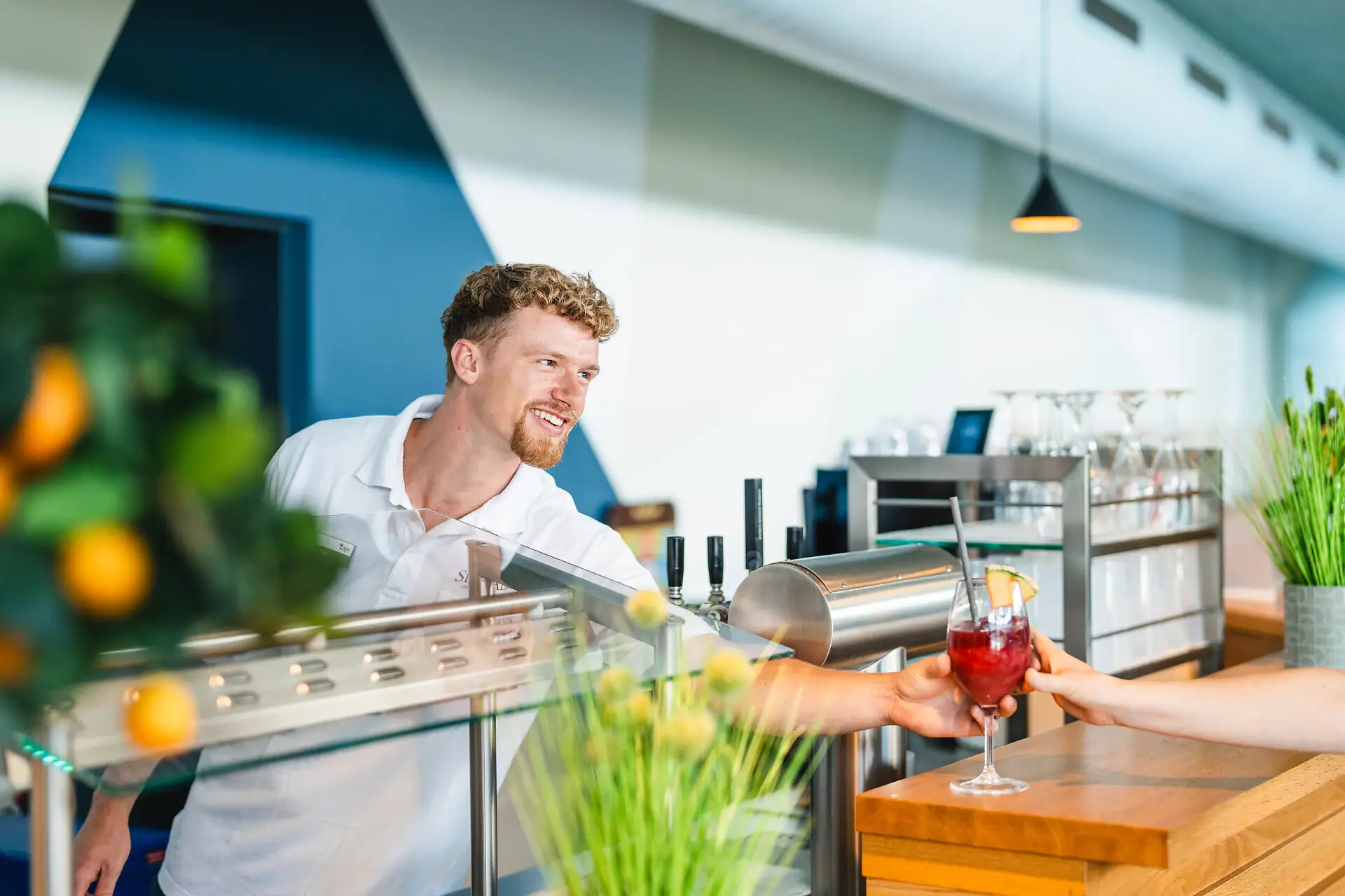 Bar bij het zwembad Een man geeft een vrouw iets te drinken.