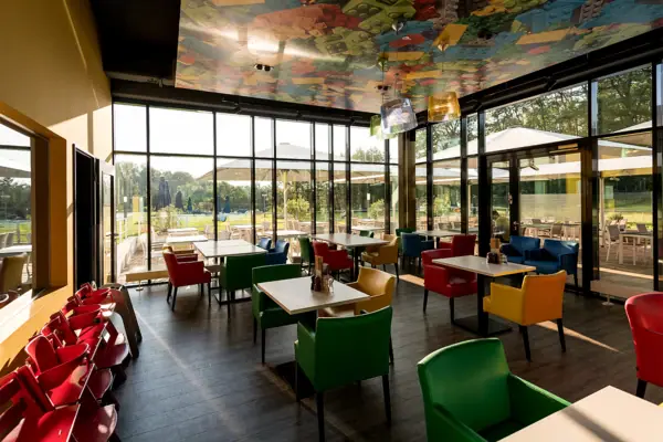 Een restaurant met kleurrijke stoelen en tafels.