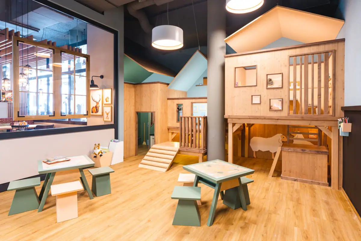 Een kamer met houten meubels en een speelhuisje.