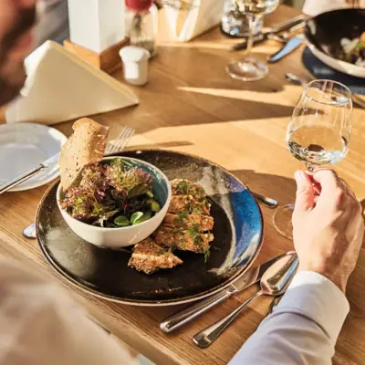 Restaurant Werfenweng Een man eet een maaltijd van een bord.