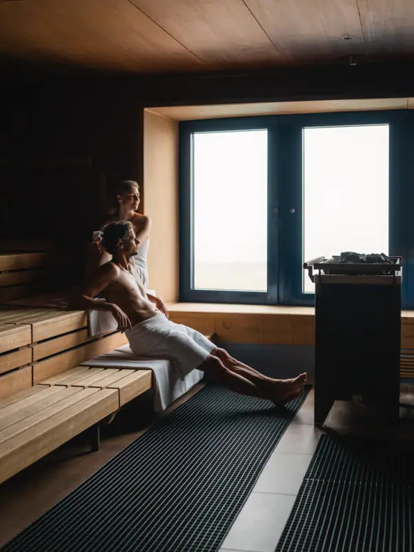 Een man en een vrouw zitten in een sauna.
