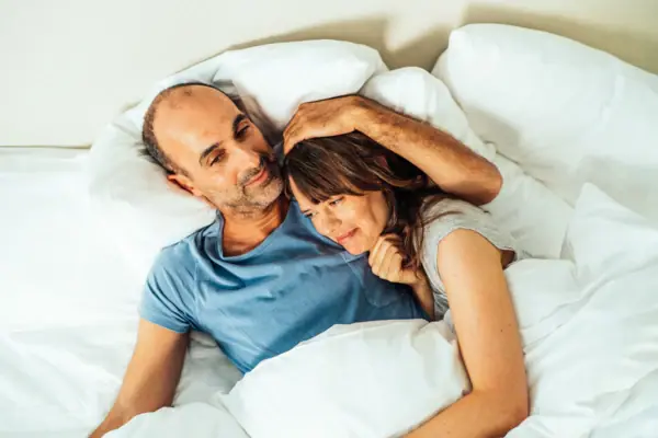 Knuffelen in bed Een man en een vrouw liggen in bed.