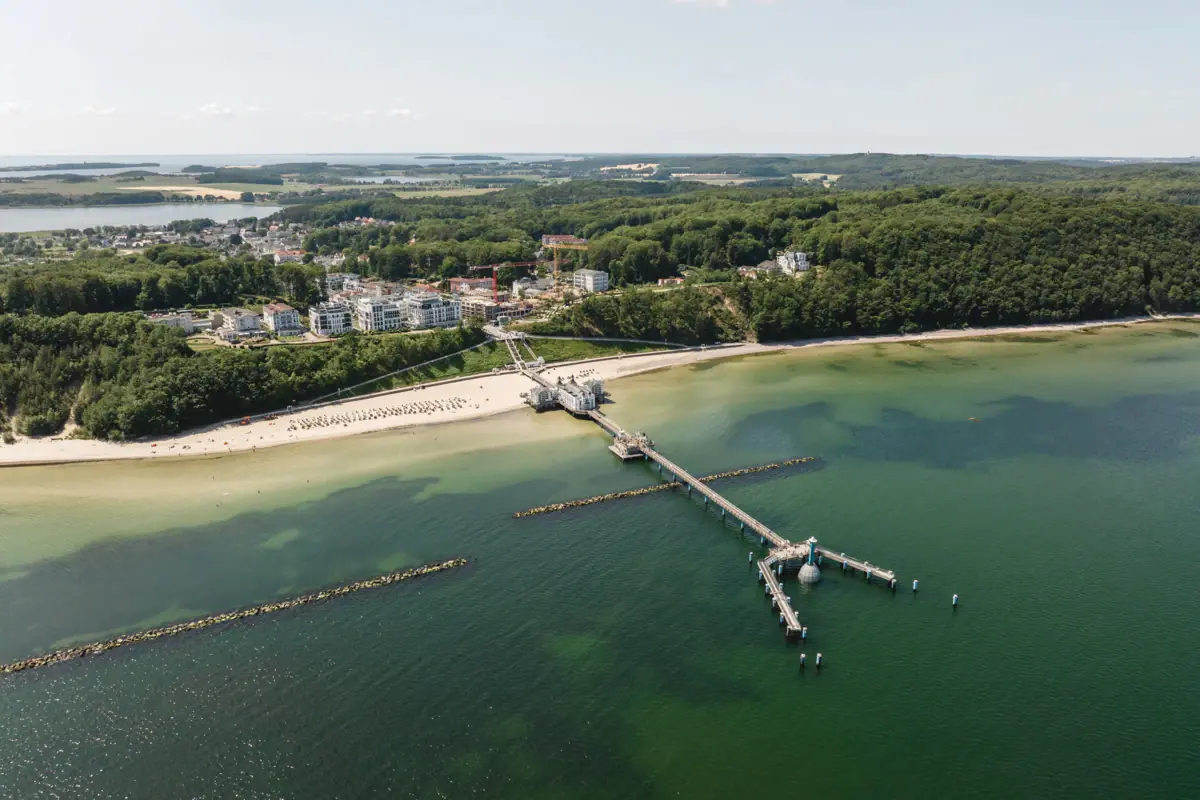 Een steiger op een strand met uitzicht op het water en de lucht.