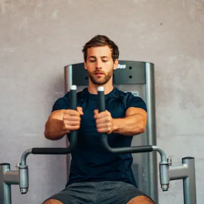 Fitnessapparaat Een man traint op een fitnessapparaat.