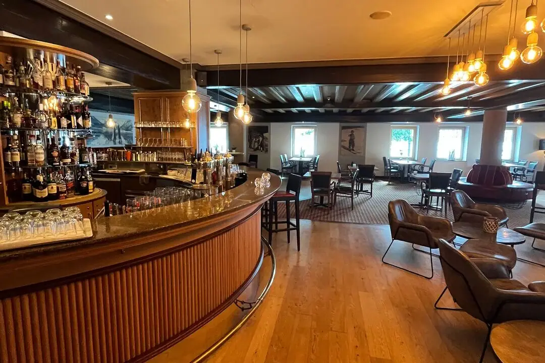 Een bar met toonbank en stoelen.