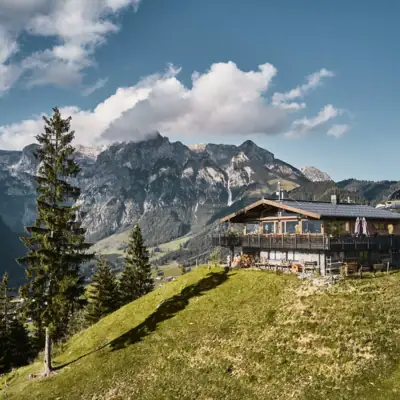 Werfenweng bergen Een hut op een heuvel voor een bergpanorama.
