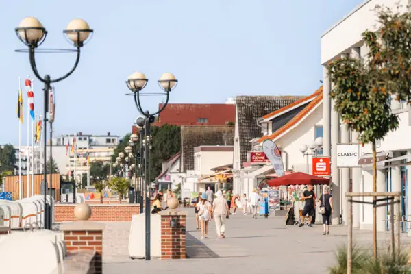 Een groep mensen loopt op een stoep.