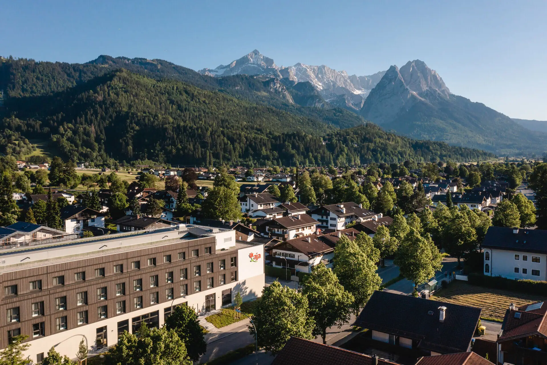 aja Garmisch-Partenkirchen Stad met bomen en bergen op de achtergrond.