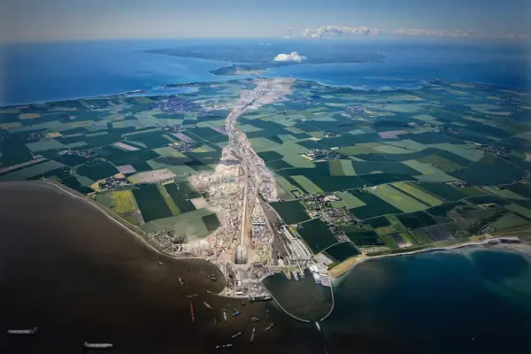 Luchtfoto van de bouwplaats van de Fehmarnbelt-tunnel, met water en land.