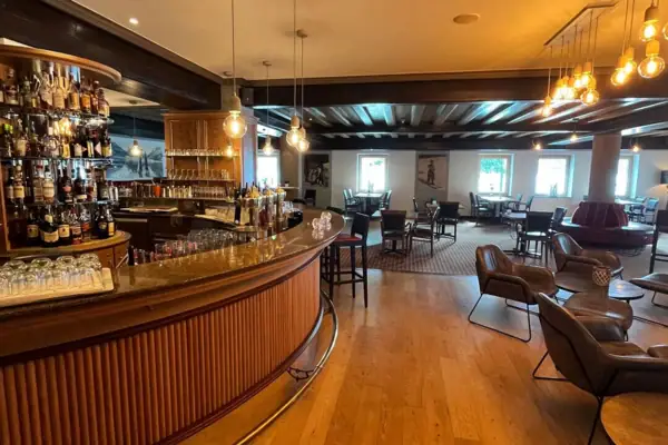 Een bar met toonbank en stoelen.