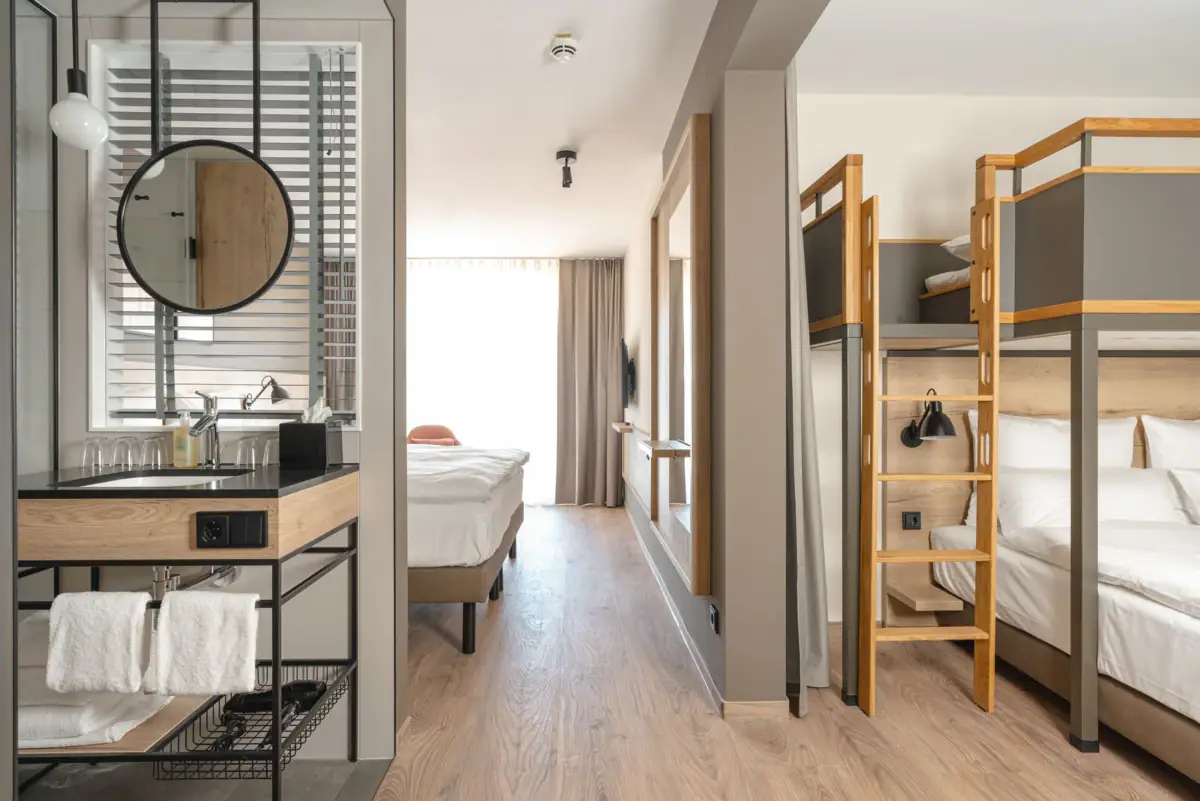 Familiekamer Een kamer met een stapelbed en een spiegel.