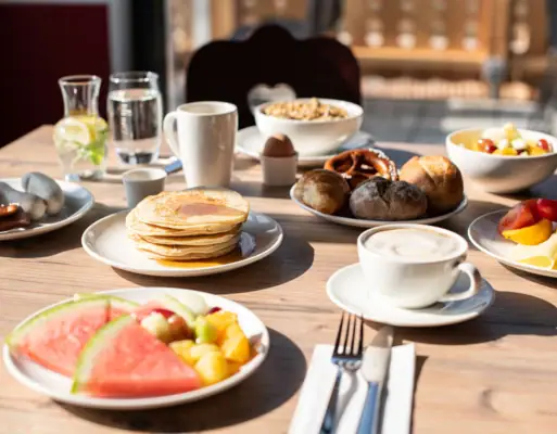 Een tafel met borden vol eten en drinken.
