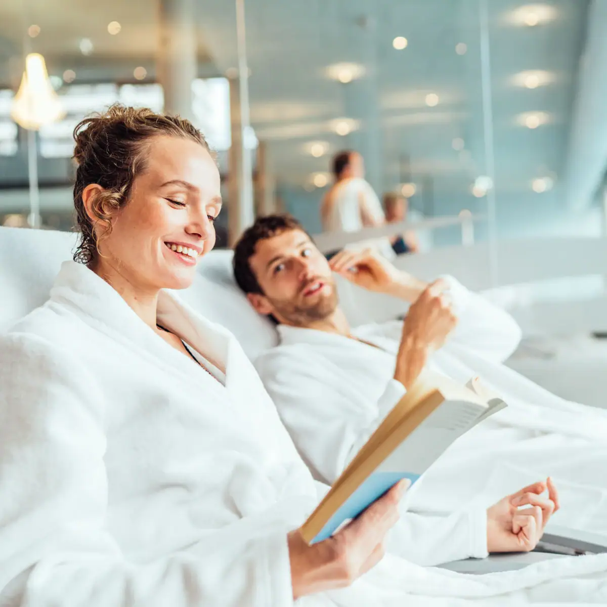 Een man en een vrouw in badjassen lezen een boek.