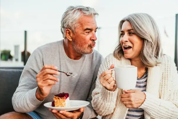 Koffiepauze Een man en een vrouw eten taart.