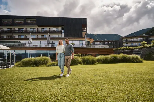 Een man en een vrouw lopen over een grasveld.