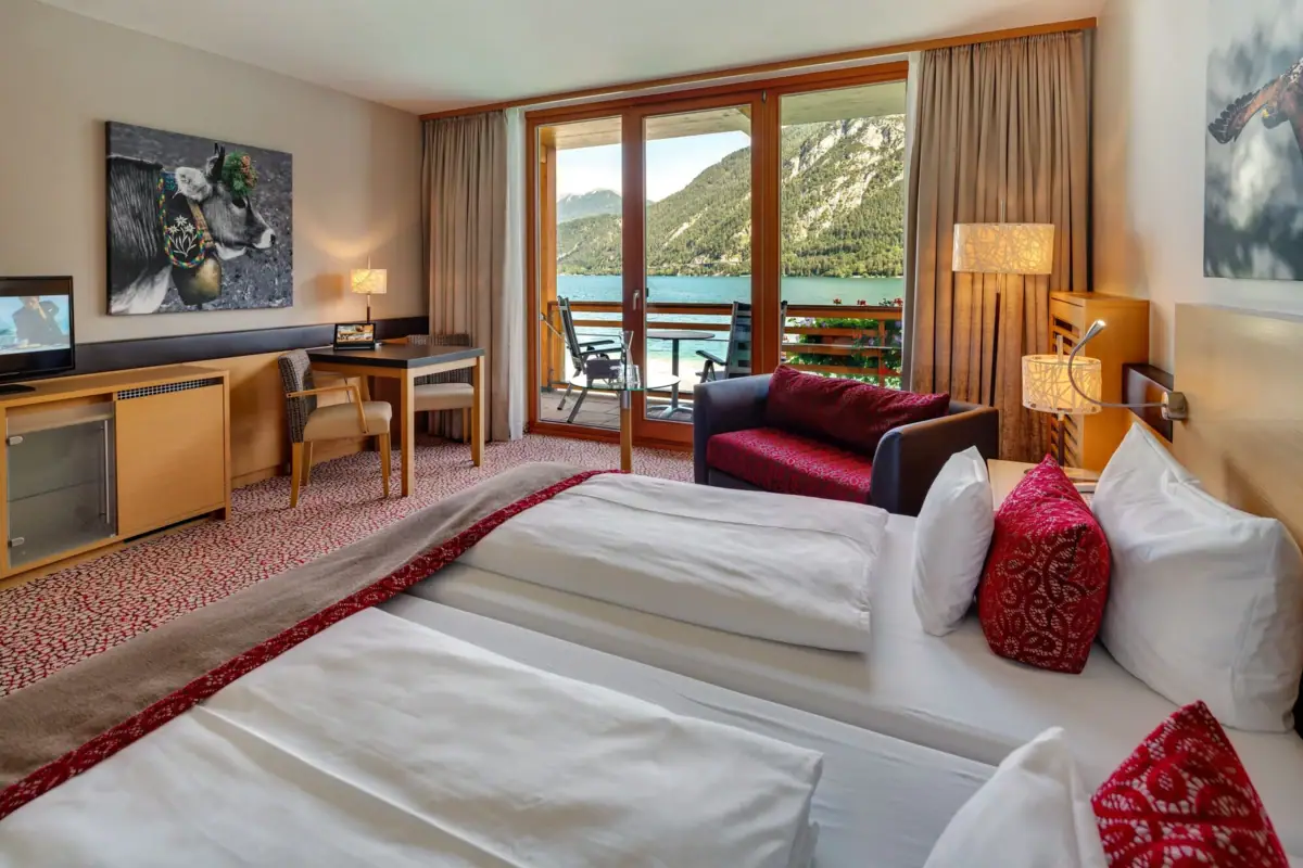 Een kamer met uitzicht op een meer en bergen.