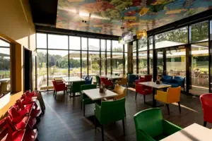 Een restaurant met kleurrijke stoelen en tafels.